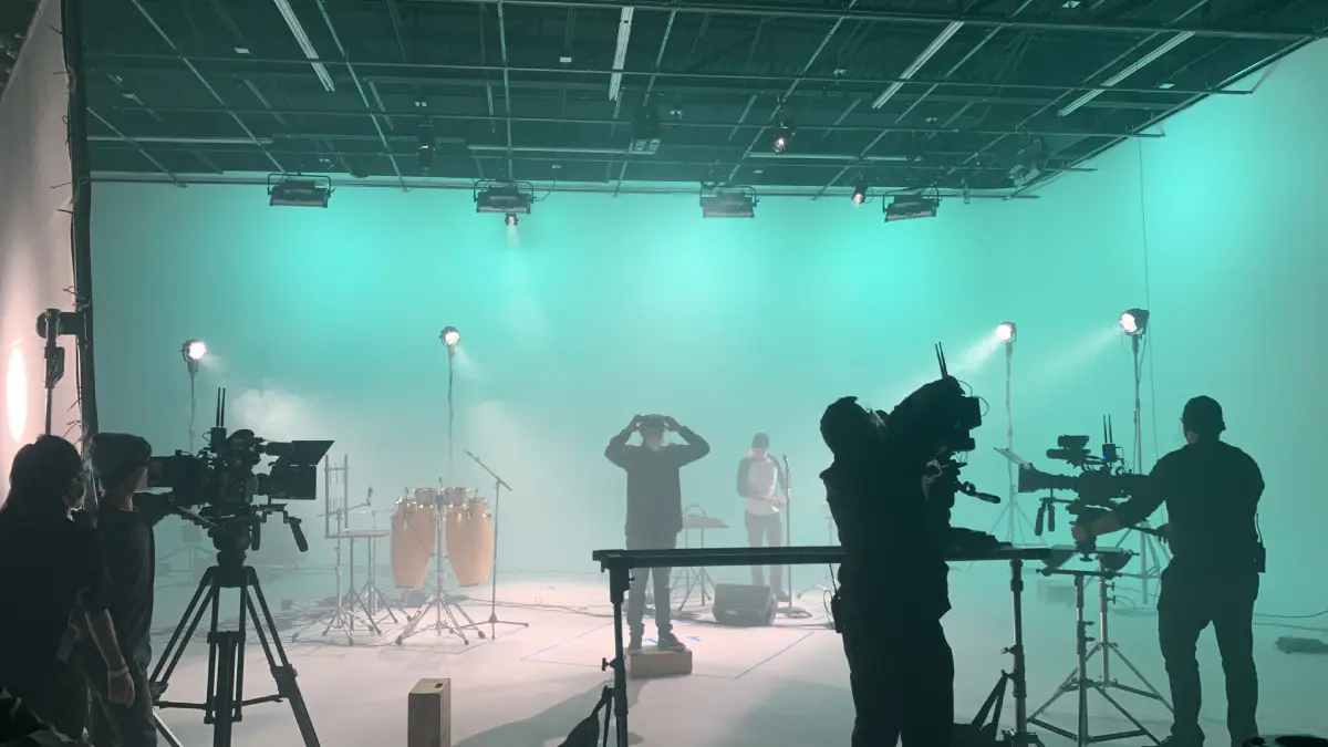 A person is filming in the middle of a green light.
