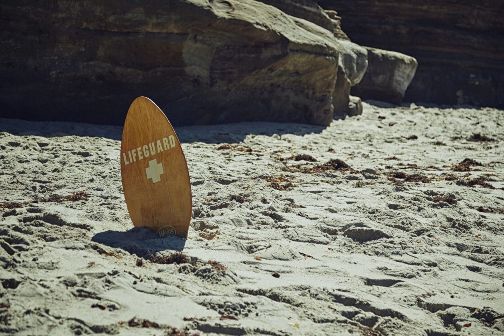 A surfboard sitting on top of the beach.