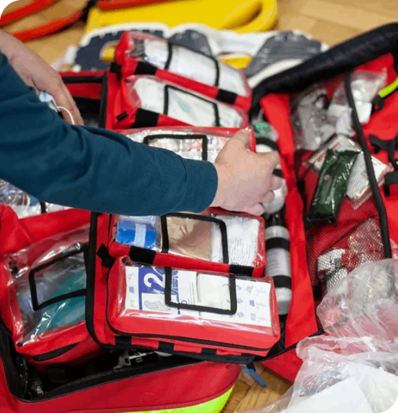 Person organizing a red medical kit.